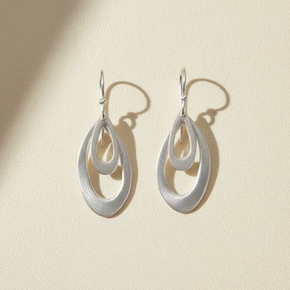 Silver leaf-shaped hoop earrings with layered teardrop design