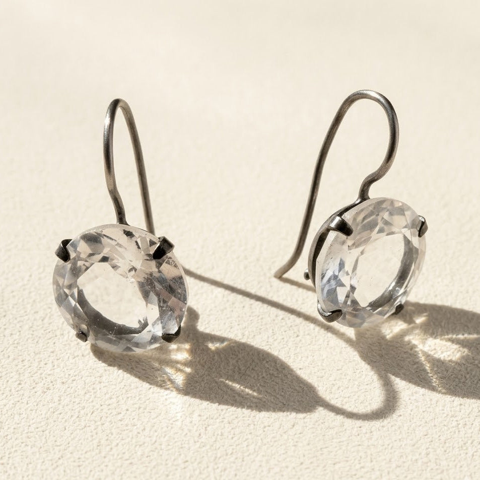 Silver-tone drop earrings with round faceted clear stone in prong setting