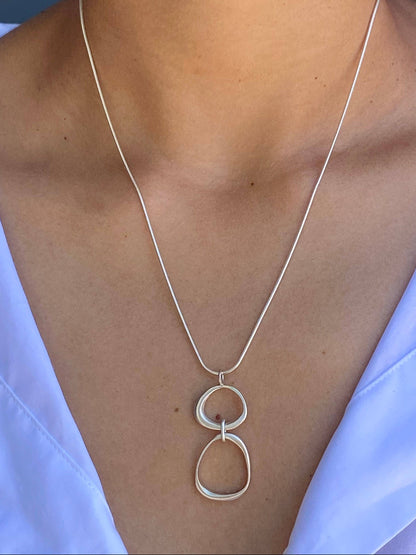 Organic circles necklace pendant with two circular loops on a thin silver chain