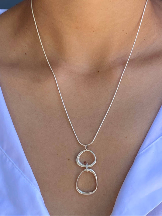 Organic circles necklace pendant with two circular loops on a thin silver chain
