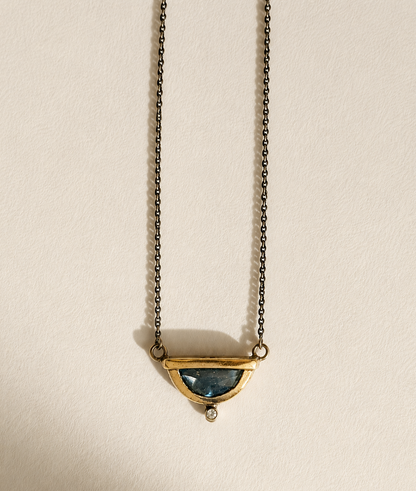 Small crescent pendant necklace with blue gemstone and gold-tone chain