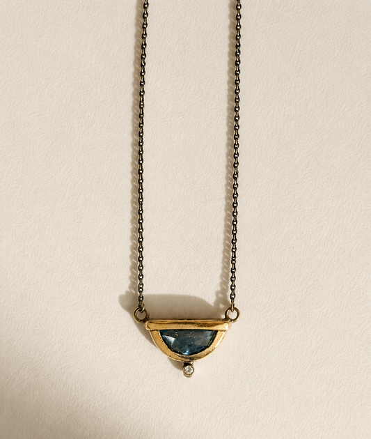 Small crescent pendant necklace with blue gemstone and gold-tone chain