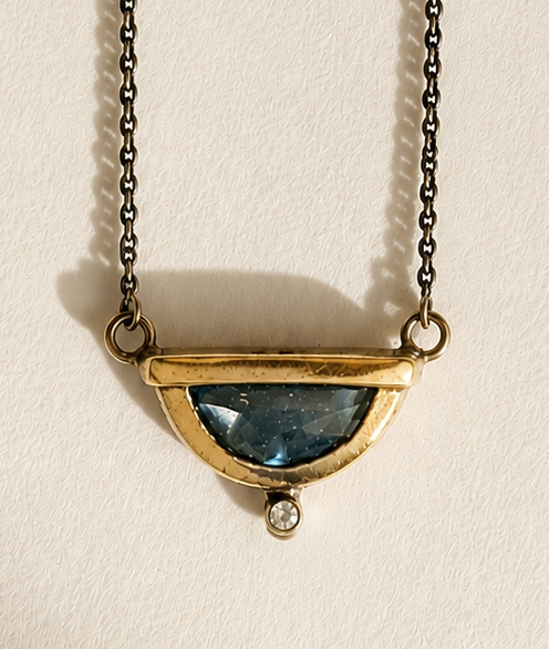 Gold-tone crescent pendant necklace with faceted blue stone and connector links