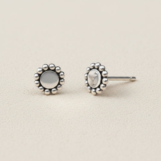 Silver earrings with floral designs on a white background