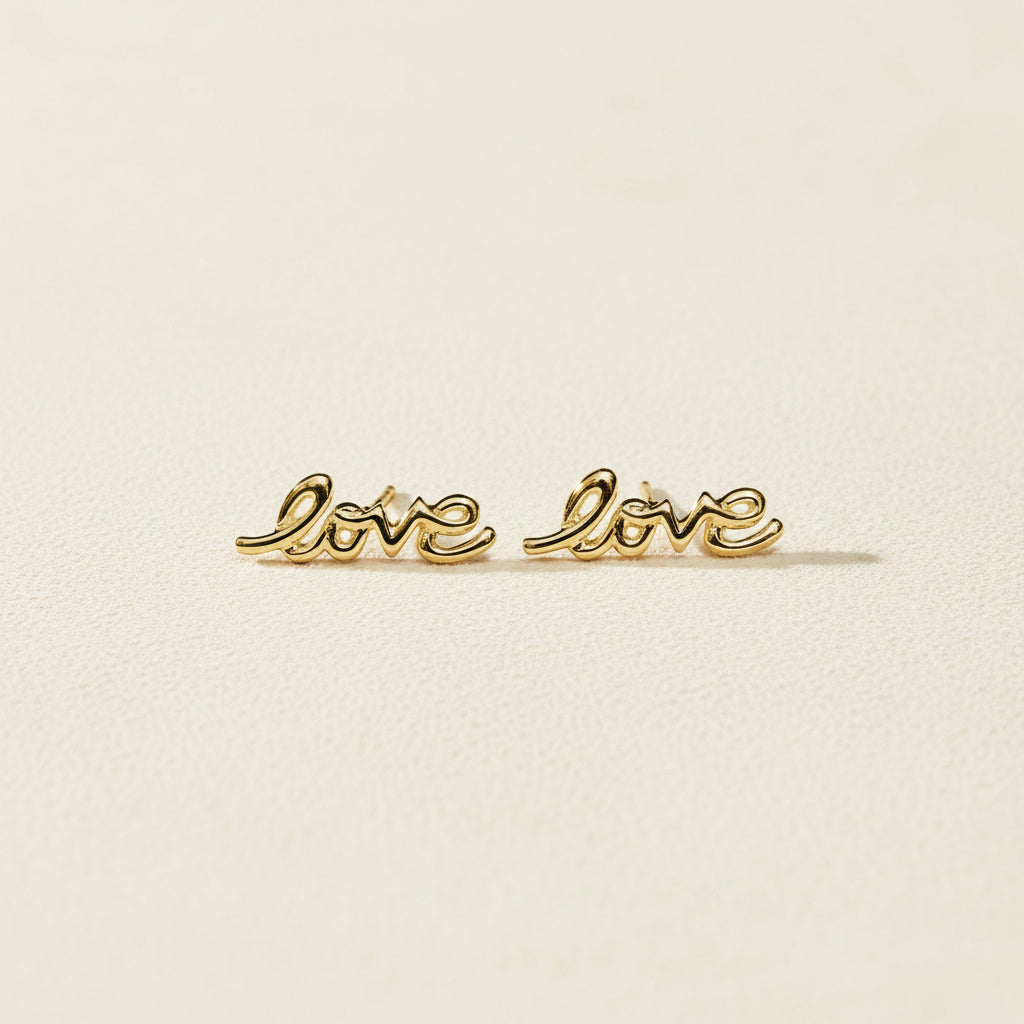 Gold Love script stud earrings, pair laid flat