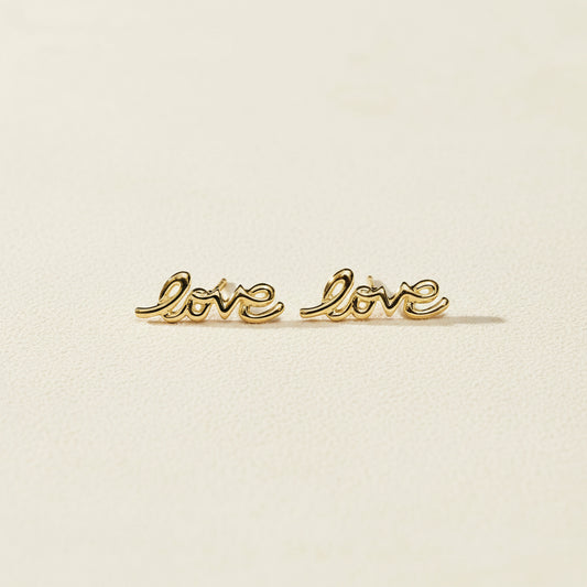 Gold Love script stud earrings, pair laid flat