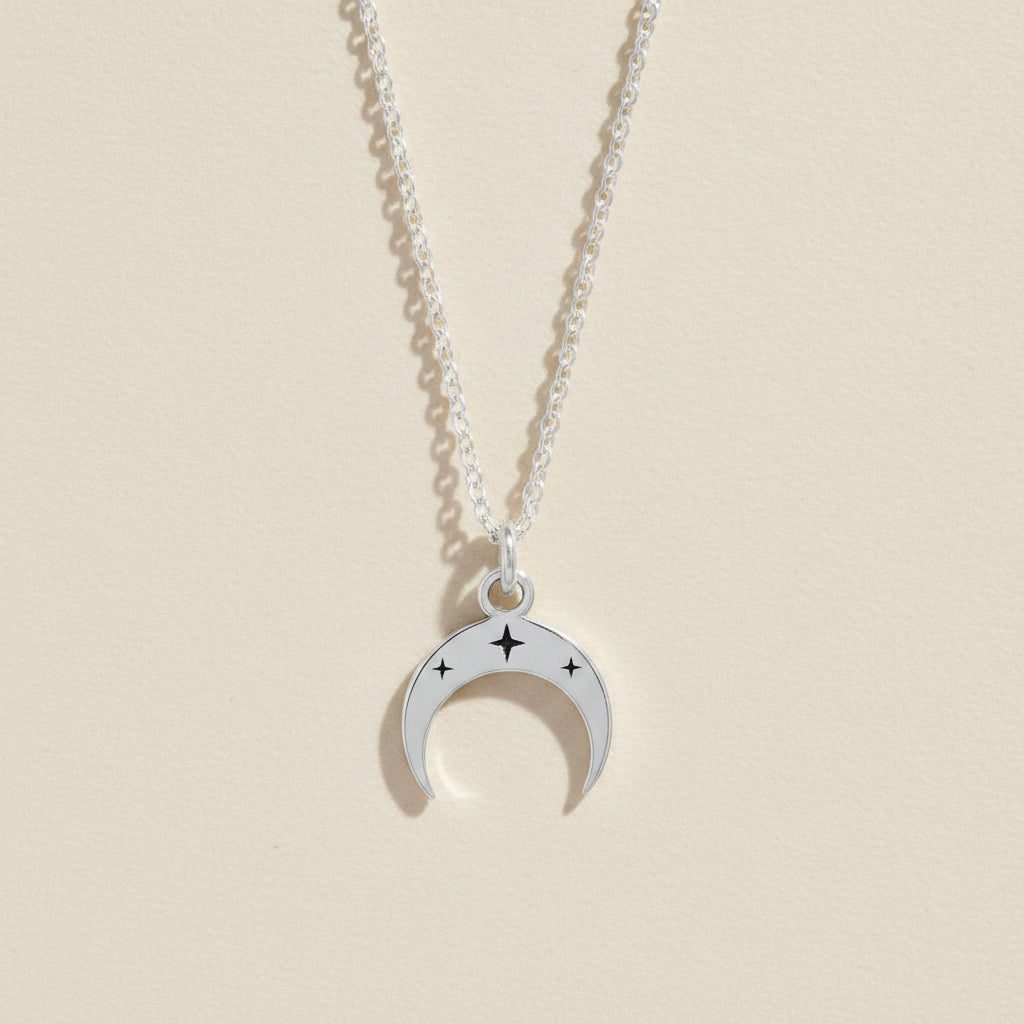 Silver-tone crescent moon necklace with star accents on a linked chain