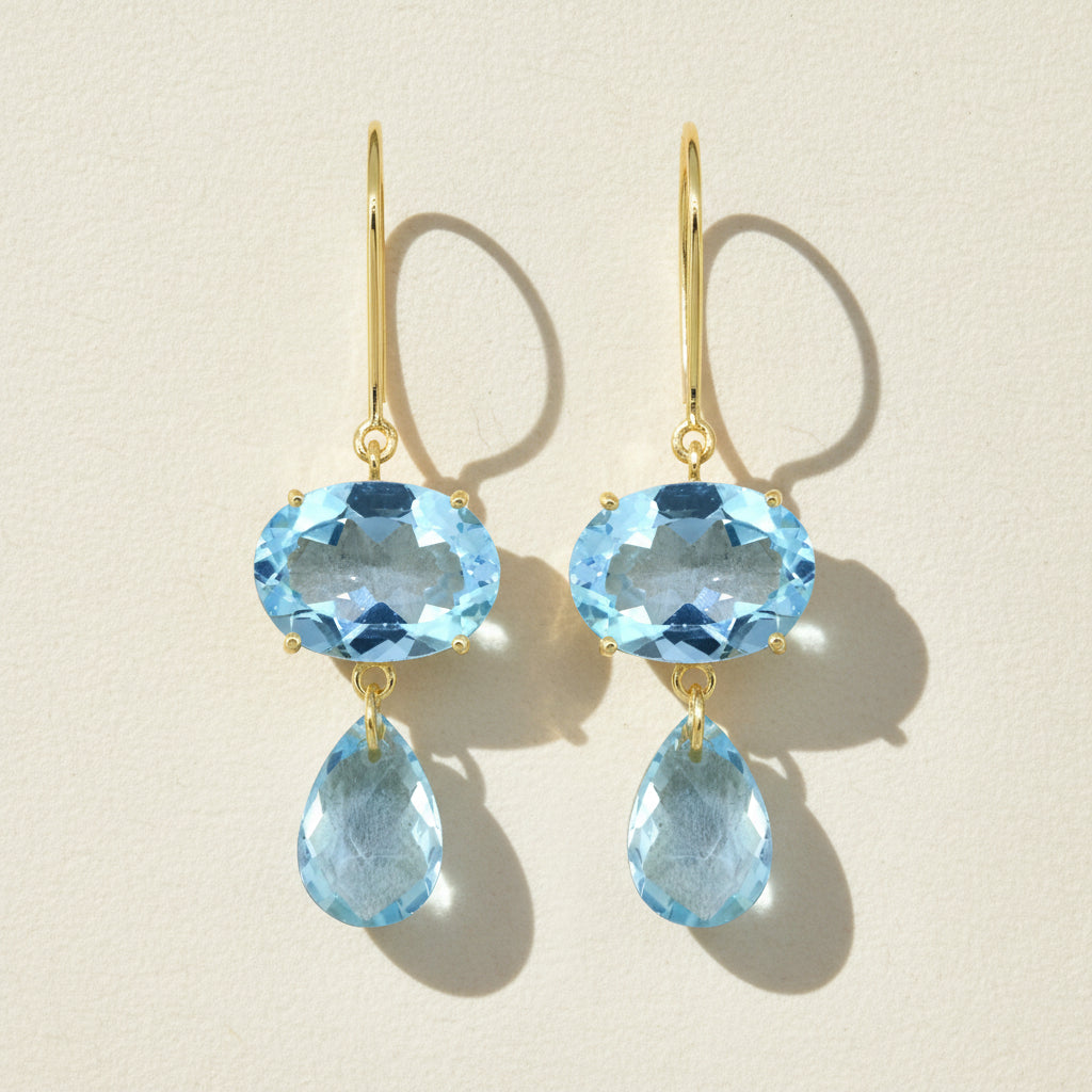 Gold-tone ear wire earrings with blue oval gemstone and blue teardrop dangle