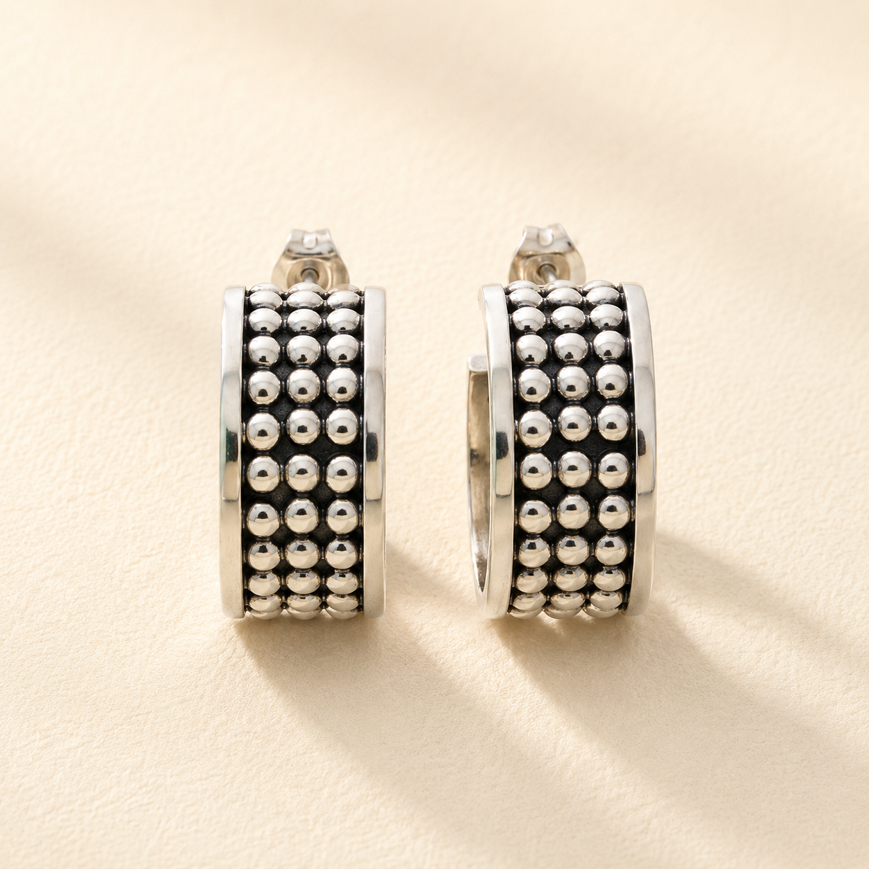 Pair of silver beaded half-hoop post earrings with stacked rows of round beads