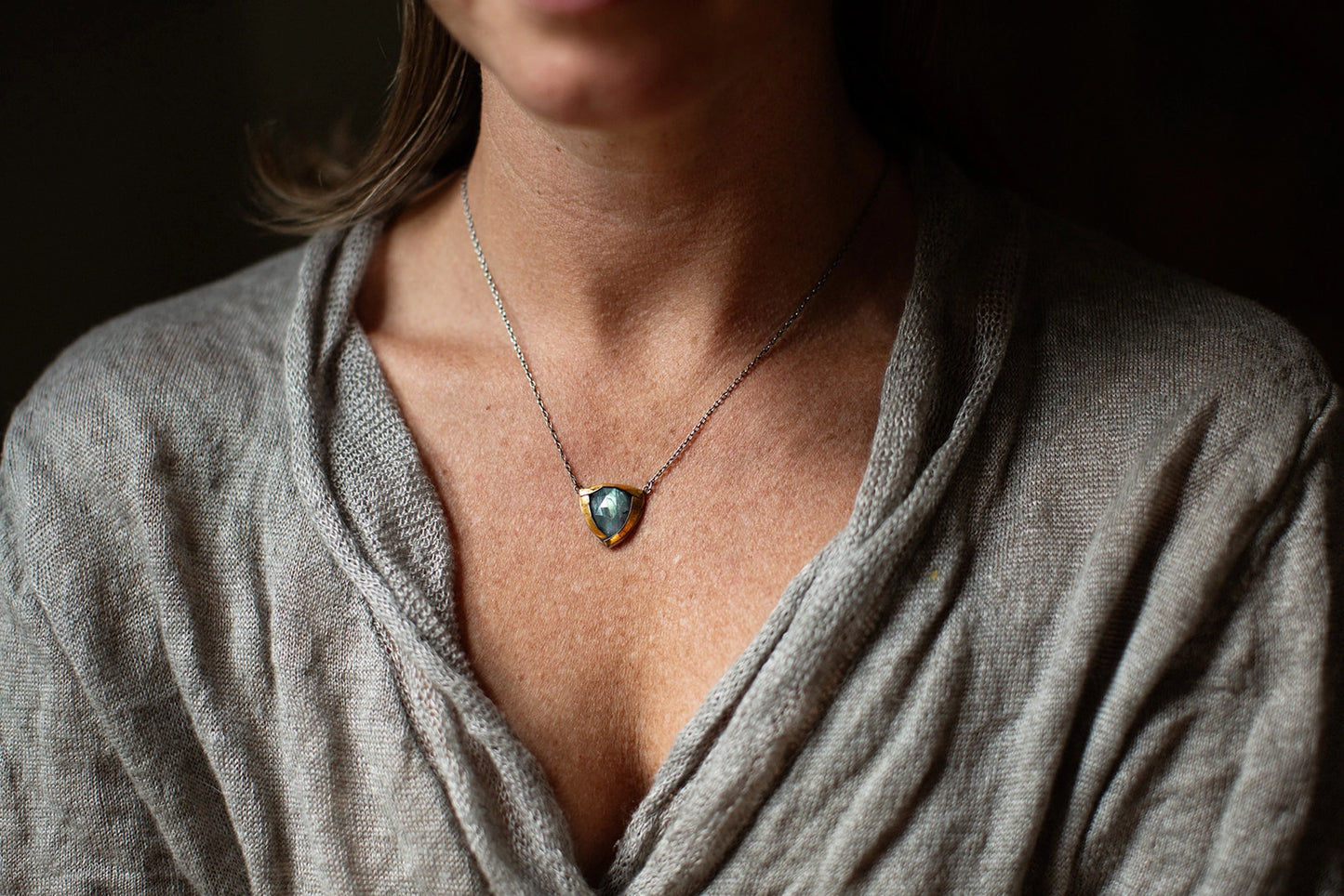 Gold-tone pendant necklace with blue teardrop stone on delicate chain