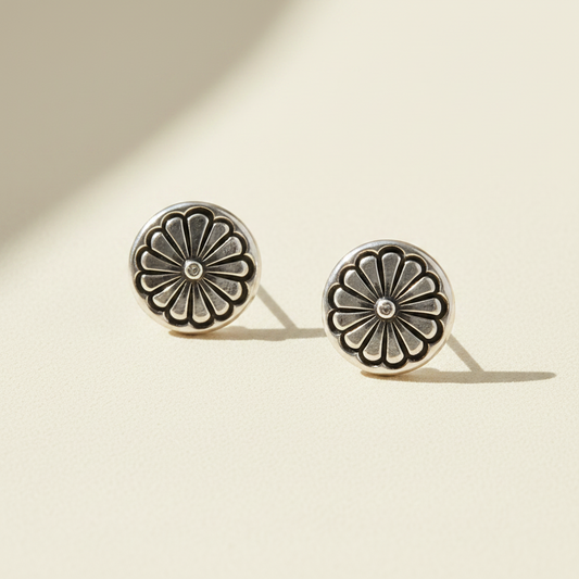 Pair of silver floral earrings on a white background