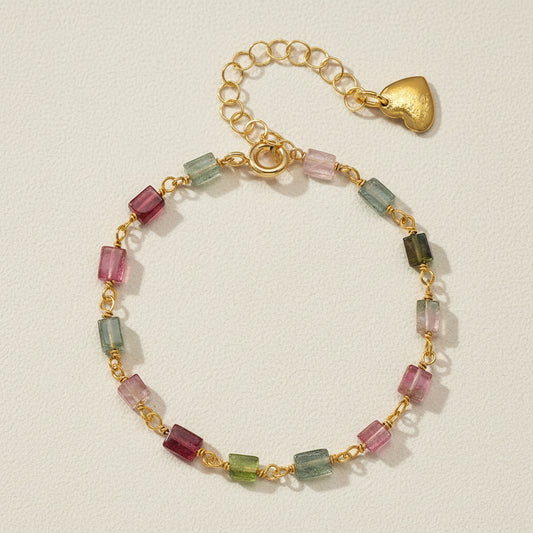 Gold-tone bead bracelet with pink, green, and teal glass links; heart toggle clasp