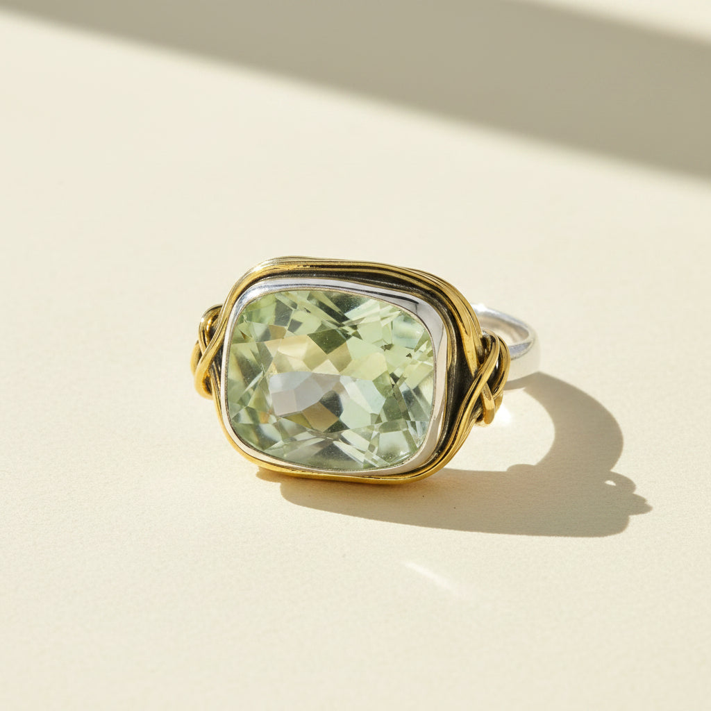 Two-tone ring with rectangular light green gemstone set in gold with silver side loops