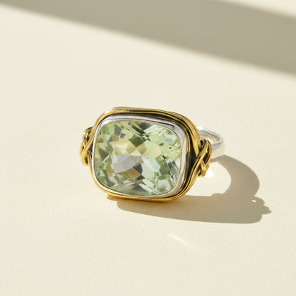 Two-tone ring with rectangular light green gemstone set in gold with silver side loops