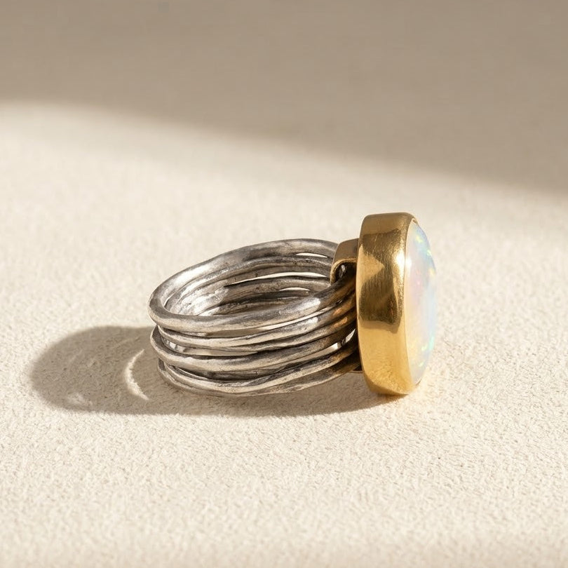 Nomad dancing pearl ring angled view, silver stacked bands with gold setting and opalescent pearl