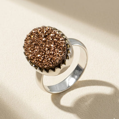 Large oval druzy ring with copper-brown glitter stone in silver bezel