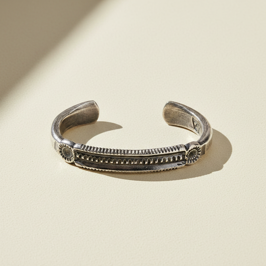 Silver-tone cuff bracelet with engraved central row and curved end tips