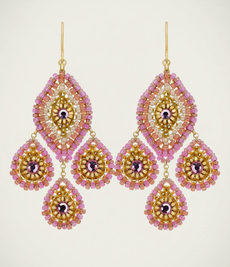 Pair of gold and pink beaded earrings on a light beige background