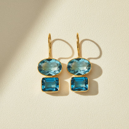 Gold-tone double drop earrings with oval and square teal-blue gemstones