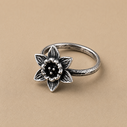 Sterling silver ring with a five-petal flower motif and bead center