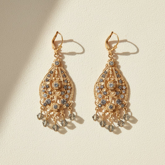 Gold-tone ornate drop earrings with dangling crystals and round center stones