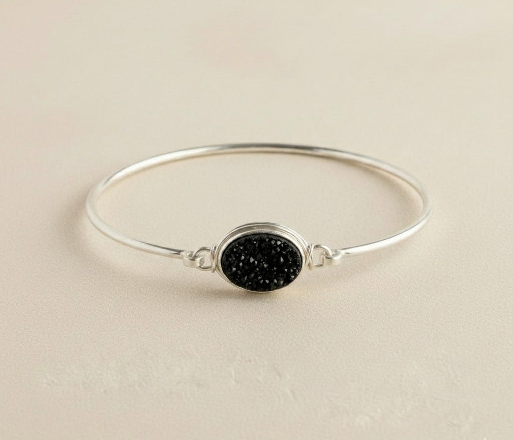 Sterling silver bangle bracelet with round black druzy stone centerpiece