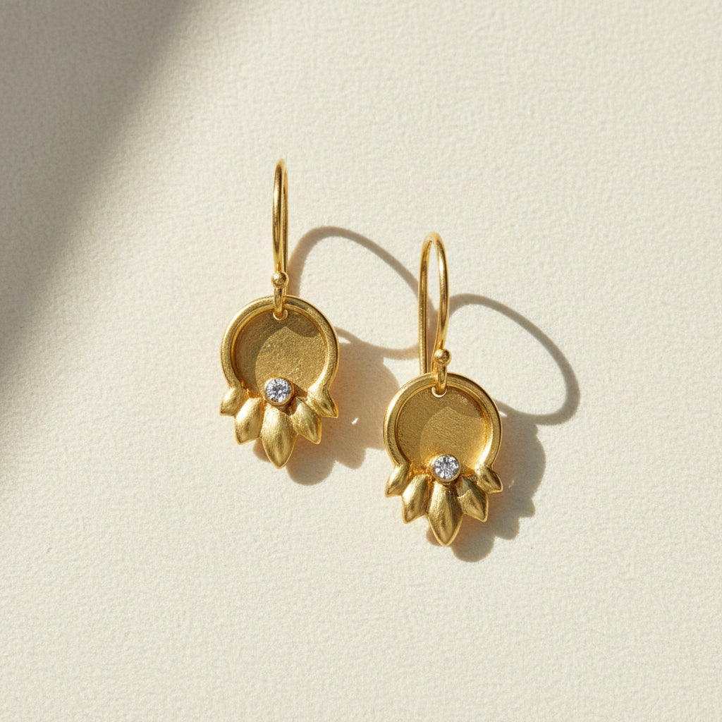 Gold-tone drop earrings with round flower charm and small crystal stud, hinged hoops