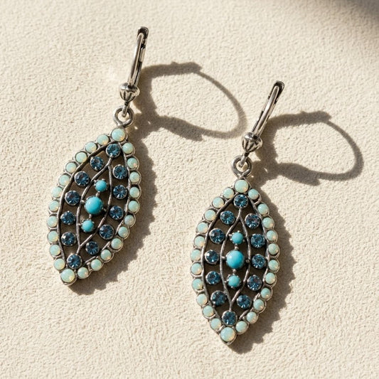 Silver dangle earrings with blue opal teardrop stones and clustered leaf design