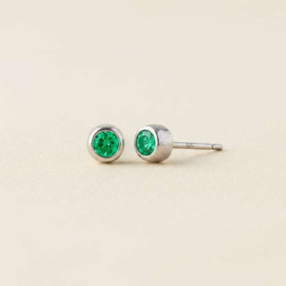 Tiny birthstone stud earrings with round green emerald CZ in silver-tone settings