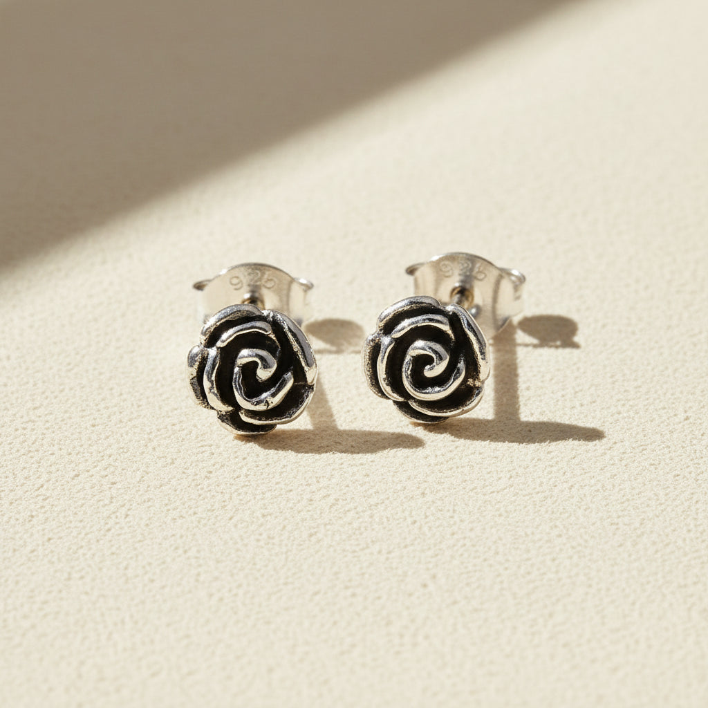 Silver-tone rose swirl stud earrings with black enamel center