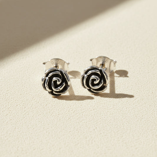 Silver-tone rose swirl stud earrings with black enamel center
