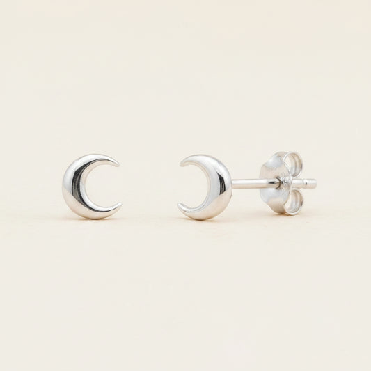 Silver crescent moon stud earrings with circular backing and push-back posts.