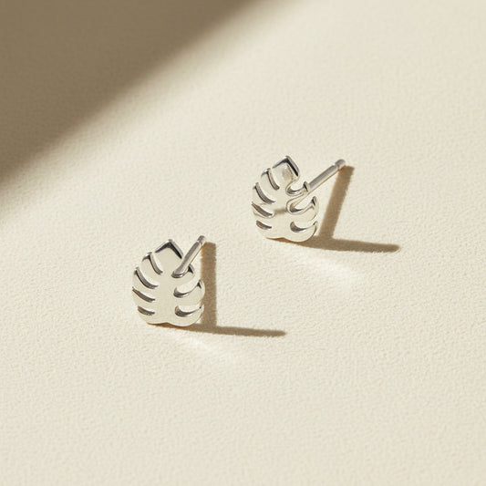 Silver-tone tropical leaf stud earrings with cutout leaf design