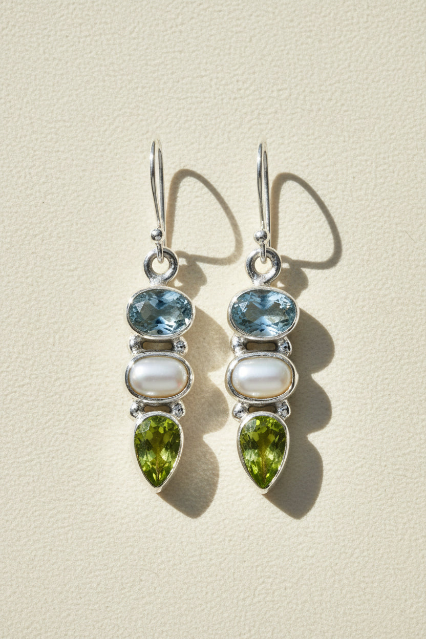 Silver-tone dangle earrings with blue gem, pearl drop, and green teardrop accents