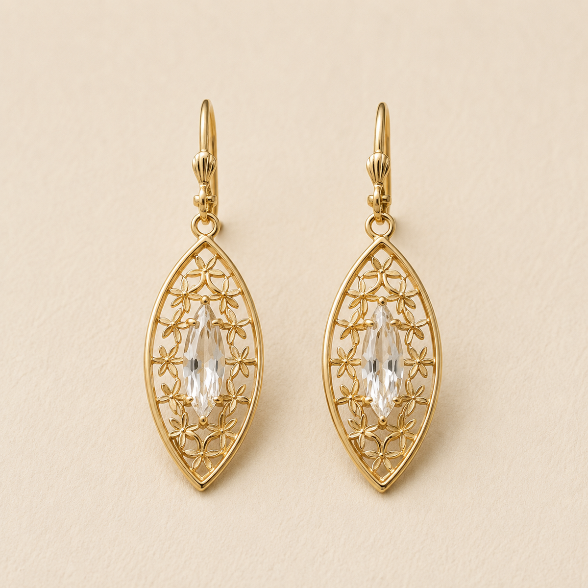 Gold-tone teardrop dangle earrings with filigree and clear faceted center