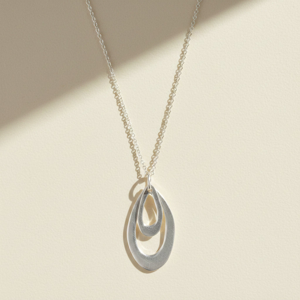 Silver-tone double leaf pendant necklace with teardrop charm and chain