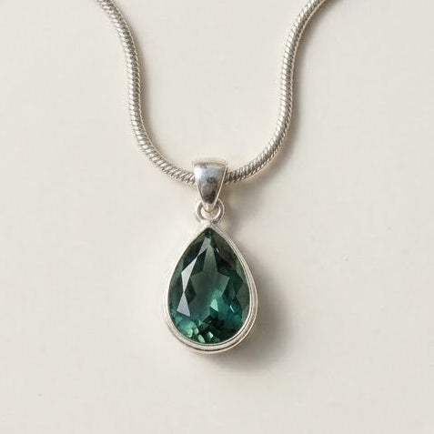 Green teardrop gemstone pendant on a silver-tone chain necklace