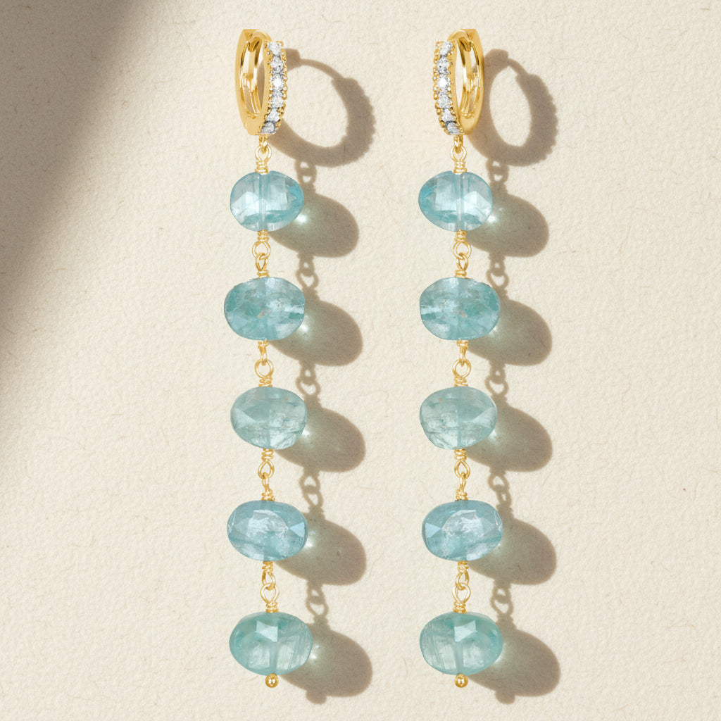 Gold-tone long drop earrings with light blue oval stones and CZ sparkle accents