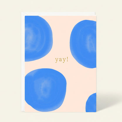 Notebook with blue abstract designs and 'yay!' text on a beige background