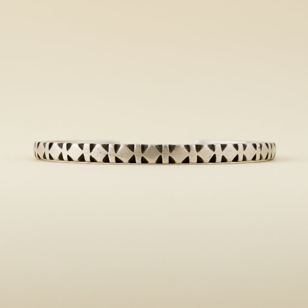 Diamond-pattern cuff bracelet with black-and-white stripe carvings
