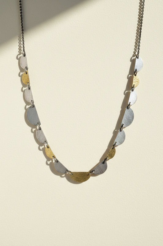 Hemi disc necklace with a long chain and stacked half-moon disc charms