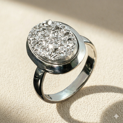 Oval druzy stone ring with silver glittery center and silver-tone bezel band