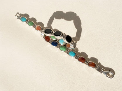 Silver reversible bracelet with turquoise and orange-brown oval cabochons and black stones