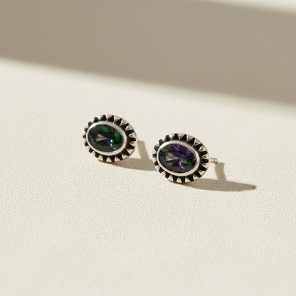 Gemstone stud earrings with dark green center and silver beaded halo