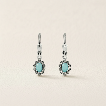 Silver-tone flower drop earrings with turquoise oval center and dark stone border