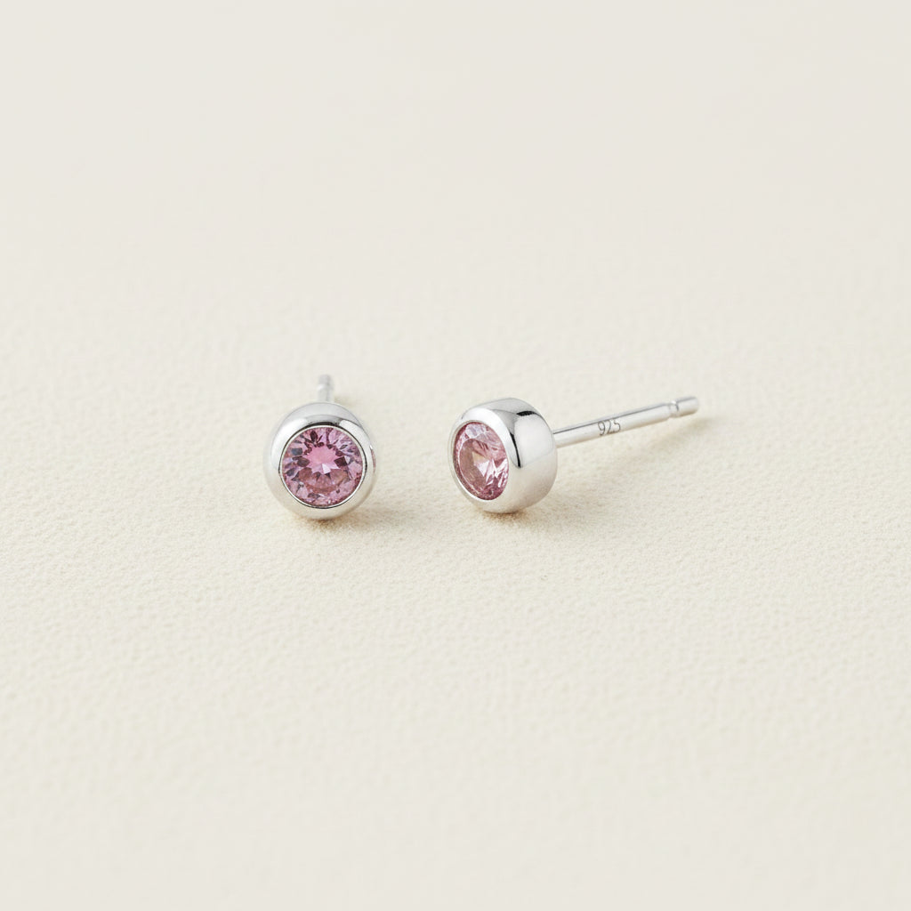 Tiny birthstone stud earrings with round pink CZ in silver-tone settings