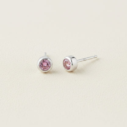 Tiny birthstone stud earrings with round pink CZ in silver-tone settings