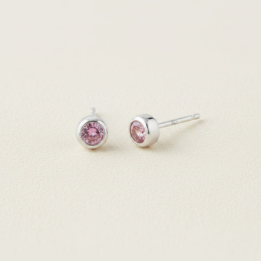 Tiny birthstone stud earrings with round pink CZ in silver-tone settings