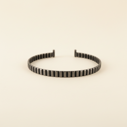 Silver round cuff bracelet with carved vertical stripe pattern and open gap