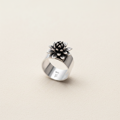 Adjustable silver ring with raised black flower cluster and small light center
